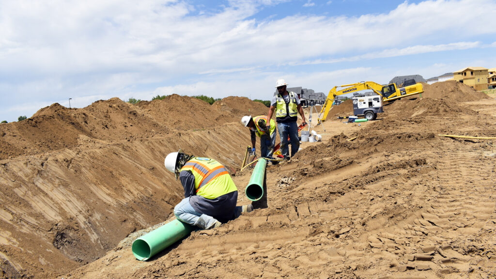 Nelson Pipeline employees laying pipe in a trench