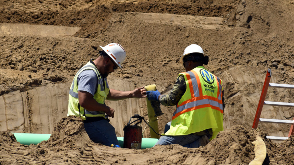Nelson Pipeline employees working on a pipe on a job site