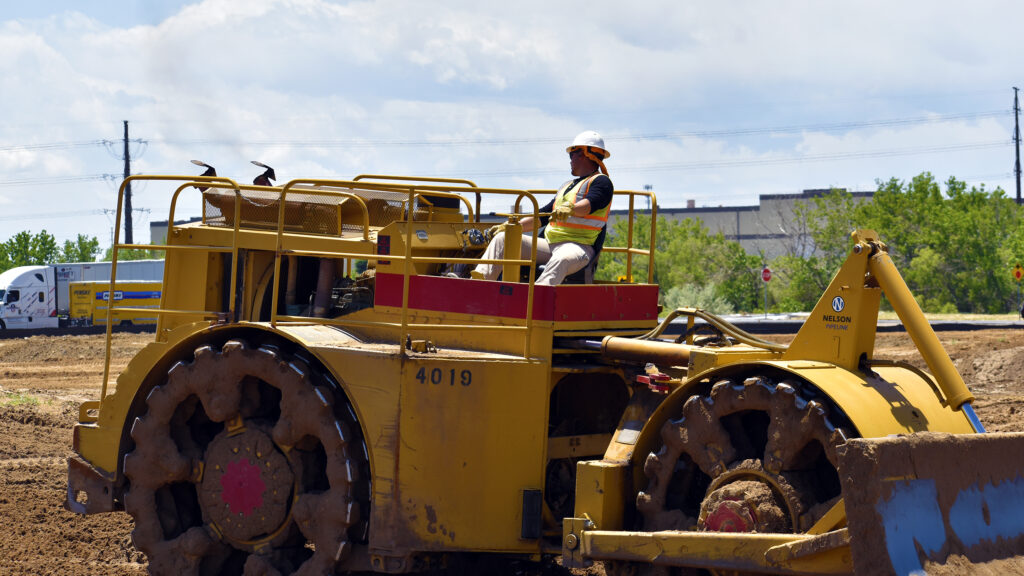 Nelson Pipeline employee driving heavy equipment