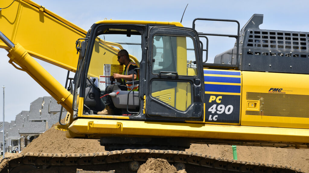 Nelson Pipeline employee operating an excavator on a job site